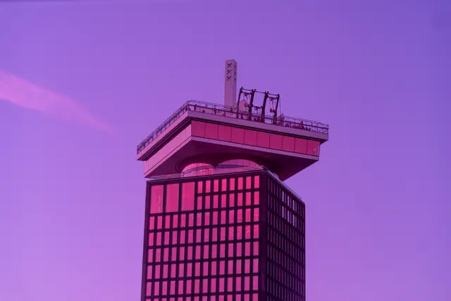 A modern observation tower under an infrared purple sky.