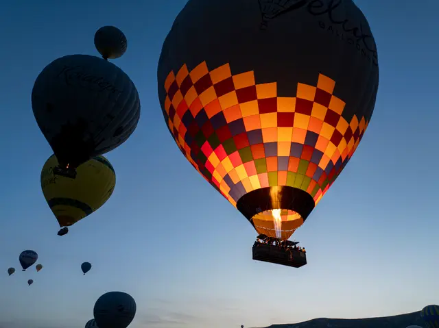 Hot air balloons drifting at dawn over Cappadocia, Turkey.